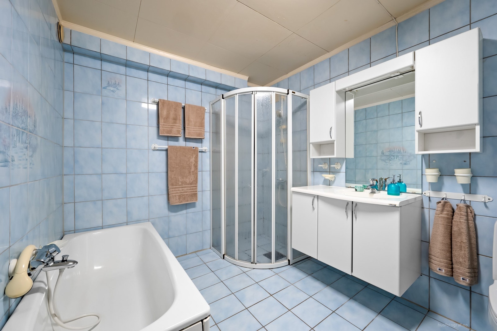 Flislagt bad fra byggeår med badekar, dusjhjørne og servantinnredning. Galleribilde