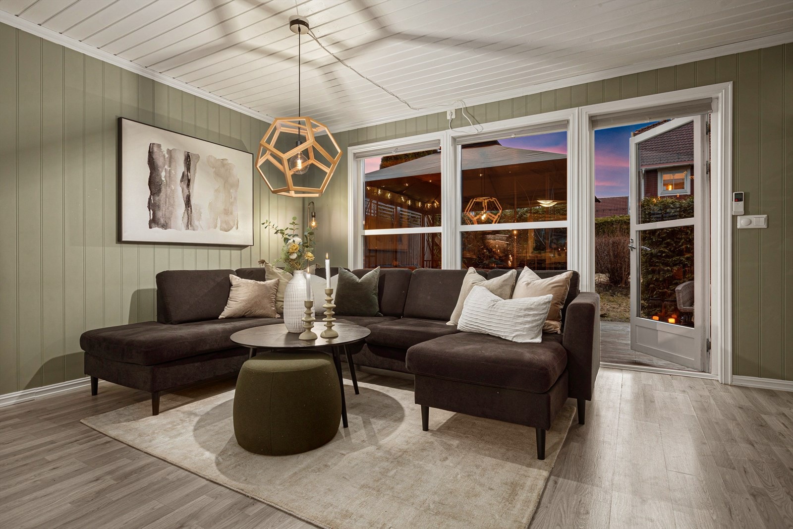 Stuen er malt i en delikat og dempet grønnfarge som gir et lunt og harmonisk preg, kombinert med lyse tak og moderne laminat som gir en fin helhet. Her det utgang til terrasse Galleribilde