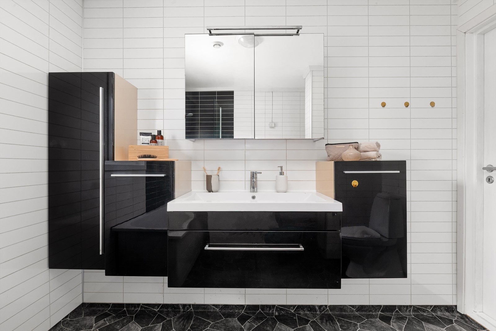 De sorte og hvite baderomsplatene gir badet et stilrent uttrykk. Galleribilde