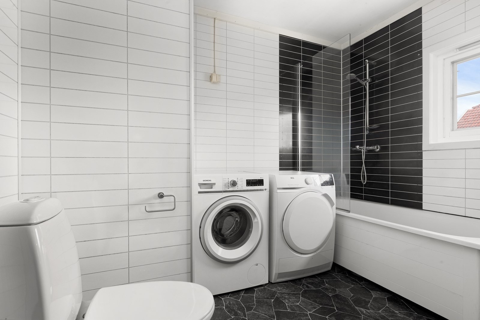 Det er opplegg for vaskemaskin og tørketrommel, som gjør badet praktisk for både klesvask og daglig bruk Galleribilde