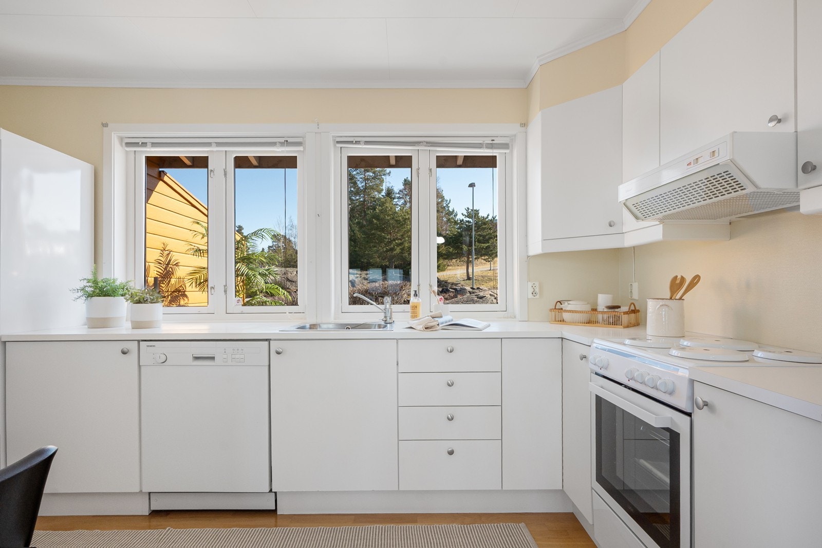 Store vindusflater med solskjerming gir godt naturlig lys og utsyn mot hyggelig fremside av boligen. Galleribilde