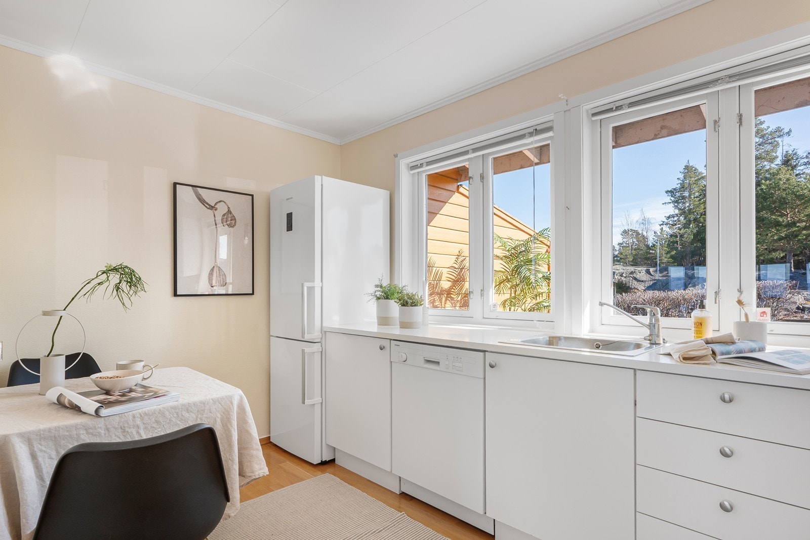 Kjøkkeninnredningen har fin oppbevaringsplass i over-, under- og høyskap med slette fronter og benkeplate i laminat. Galleribilde