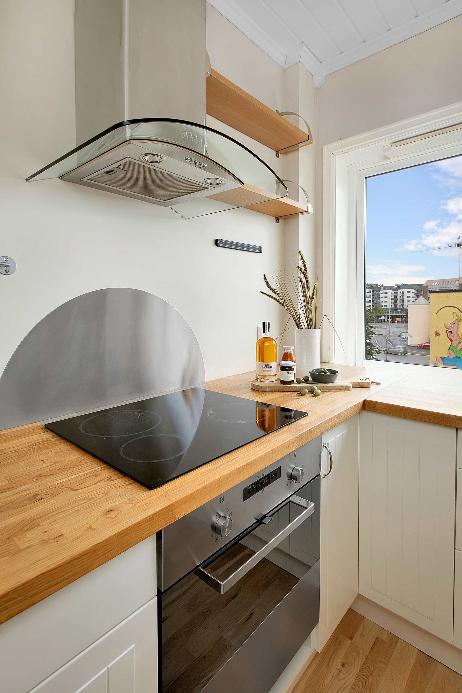 Kjøkkenet er utstyrt med integrert platetopp, stekeovn, oppvaskmaskin og frittstående kombi-kjøleskap og -fryser Galleribilde