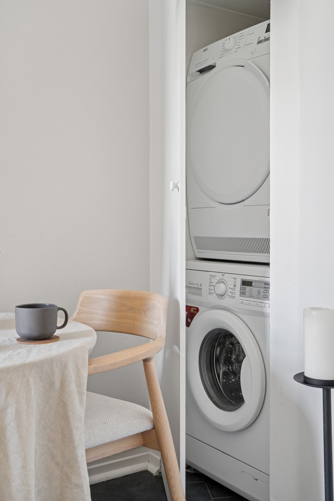 Praktisk vasjenisje i hjørnet på kjøkkenet inne i skap med plass til både tørketrommel og vaskemaskin. Galleribilde