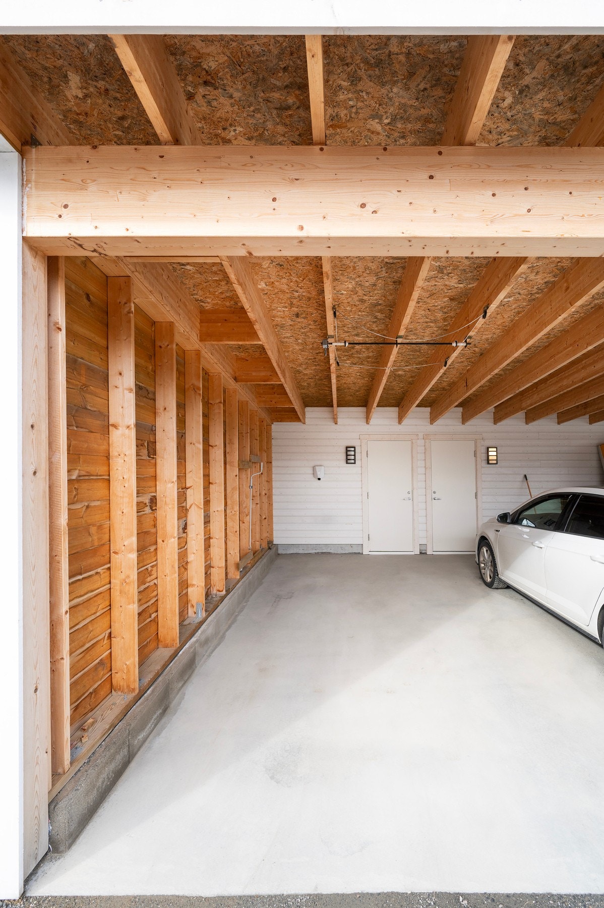 Det medfølger parkeringsplass i carport. Her er det også montert elbillader. Vegg mot vest er gjenbygd for mer ly. Galleribilde