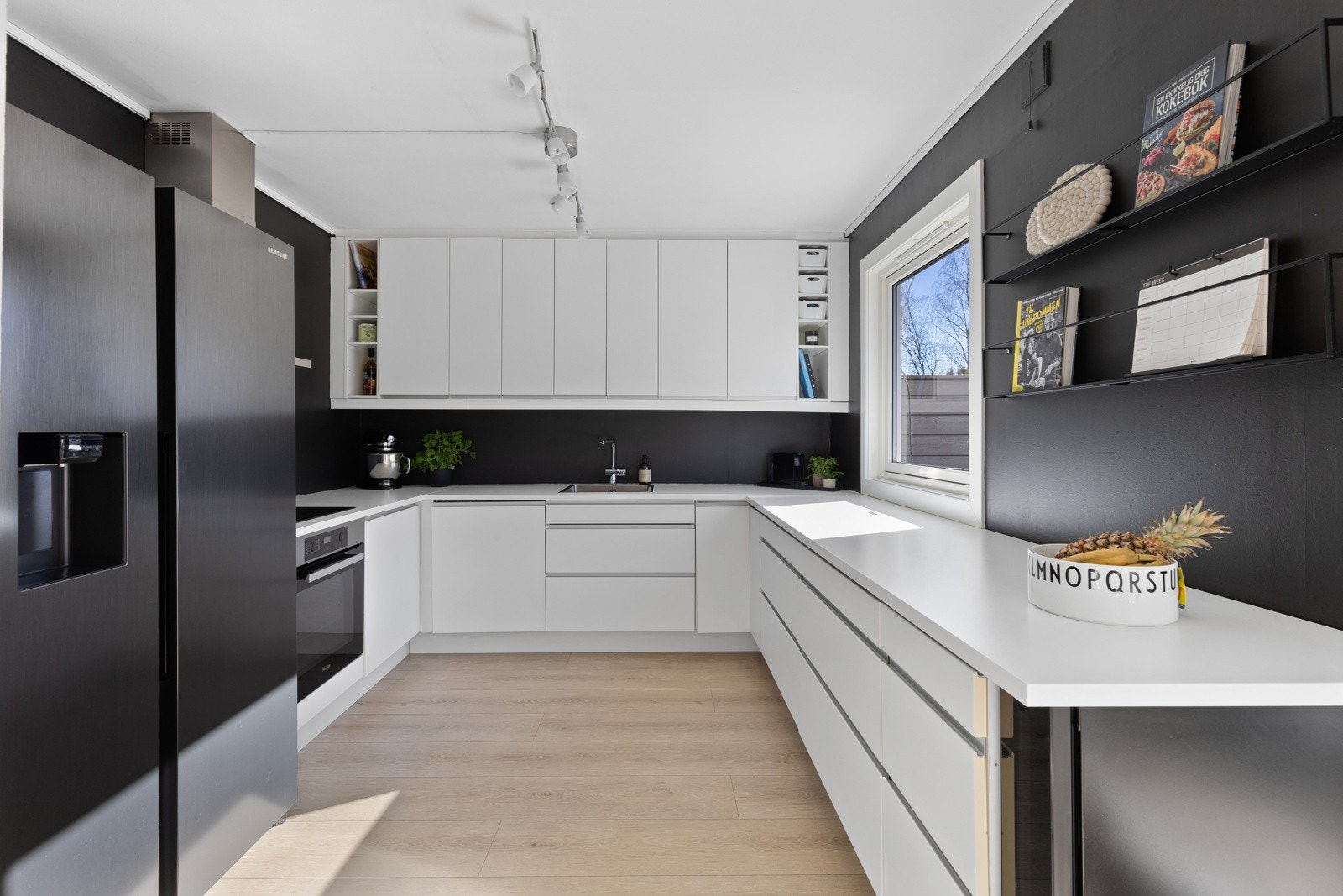 Stilrent og moderne kjøkken fra Ikea, nytt i 2012. Kjøkkenet er utformet i praktisk U-løsning, som gir godt med benke- og arbeidsplass. Innredning med hvite slette fronter med foring opp til tak og laminert benkeplate med nedfelt oppvaskkum. Galleribilde