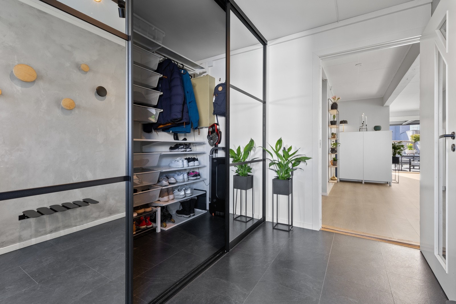 Tiltalende entre med flisimitert laminat på gulv og lysmalte veggflater, som gir et godt førsteinntrykk av boligen. Det er satt inn en flott skyvedørsgarderobe med sort omramming som gir gode lagringsmuligheter for ytterklær og sko. Galleribilde