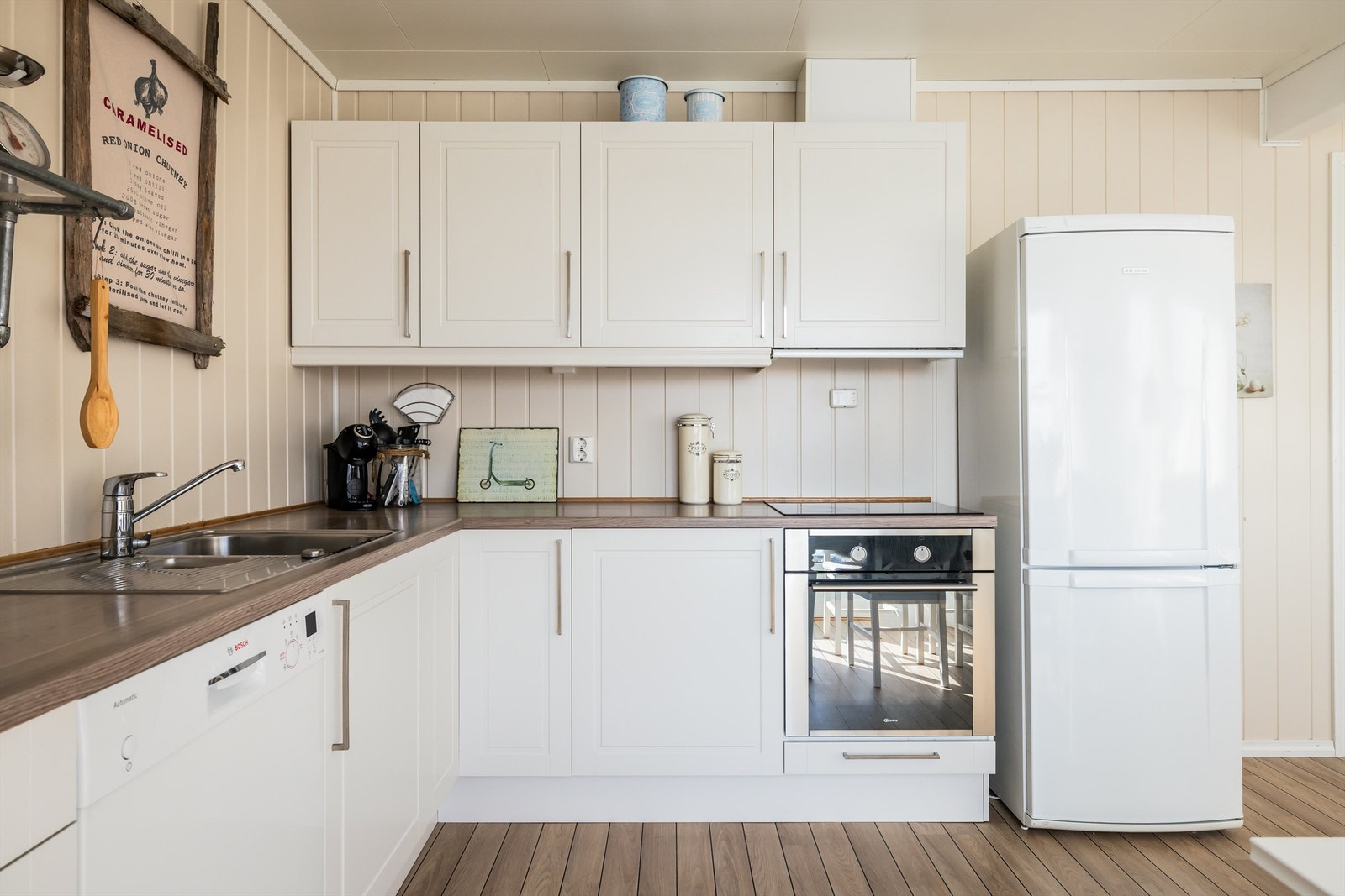 Flott kjøkken med profilerte fronter. Integrert komfyr og platetopp, oppvaskmaskin og frittstående kjøleskap med frys. Galleribilde