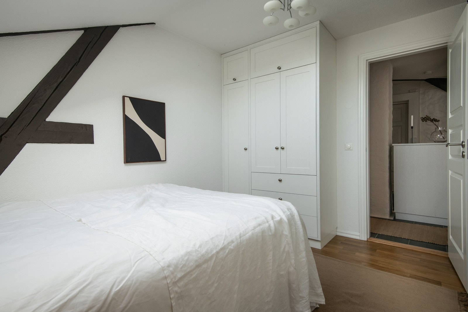 Her er det god plass til seng, nattbord og garderobe. Synlige bjelker gir rommet en varm og karakteristisk stil som harmonerer med resten av boligens særpreg. Galleribilde