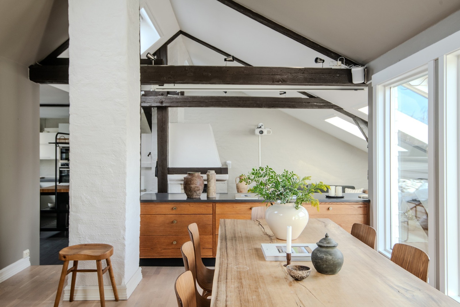 Her bor du høyt og luftig med generøs takhøyde, synlige bjelker og en gjennomgående stilfull atmosfære. Galleribilde