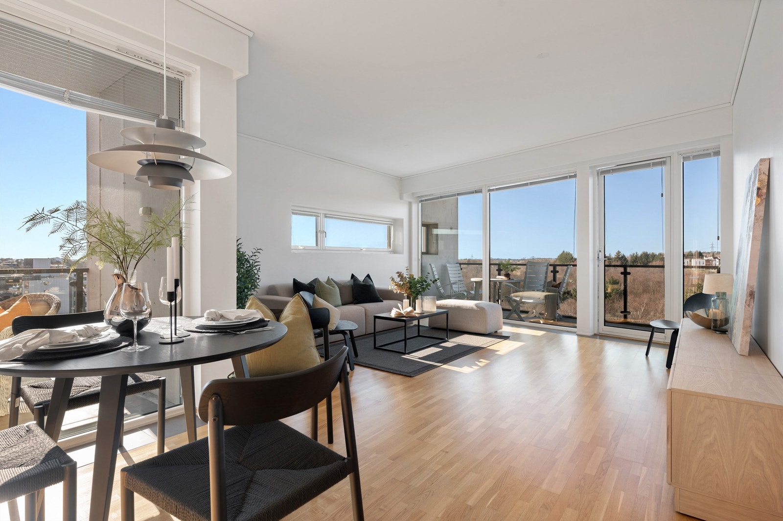 Stuen føles åpen og lys med god takhøye og store vindusflater Galleribilde