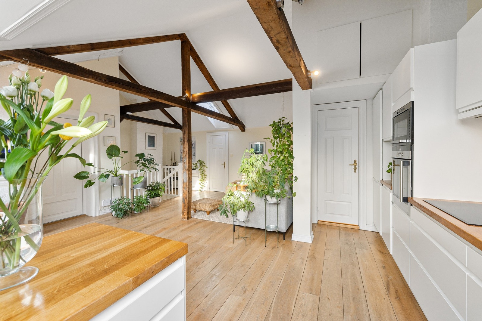 De originale, synlige takbjelkene tilfører særpreg og sjel til rommet. Galleribilde