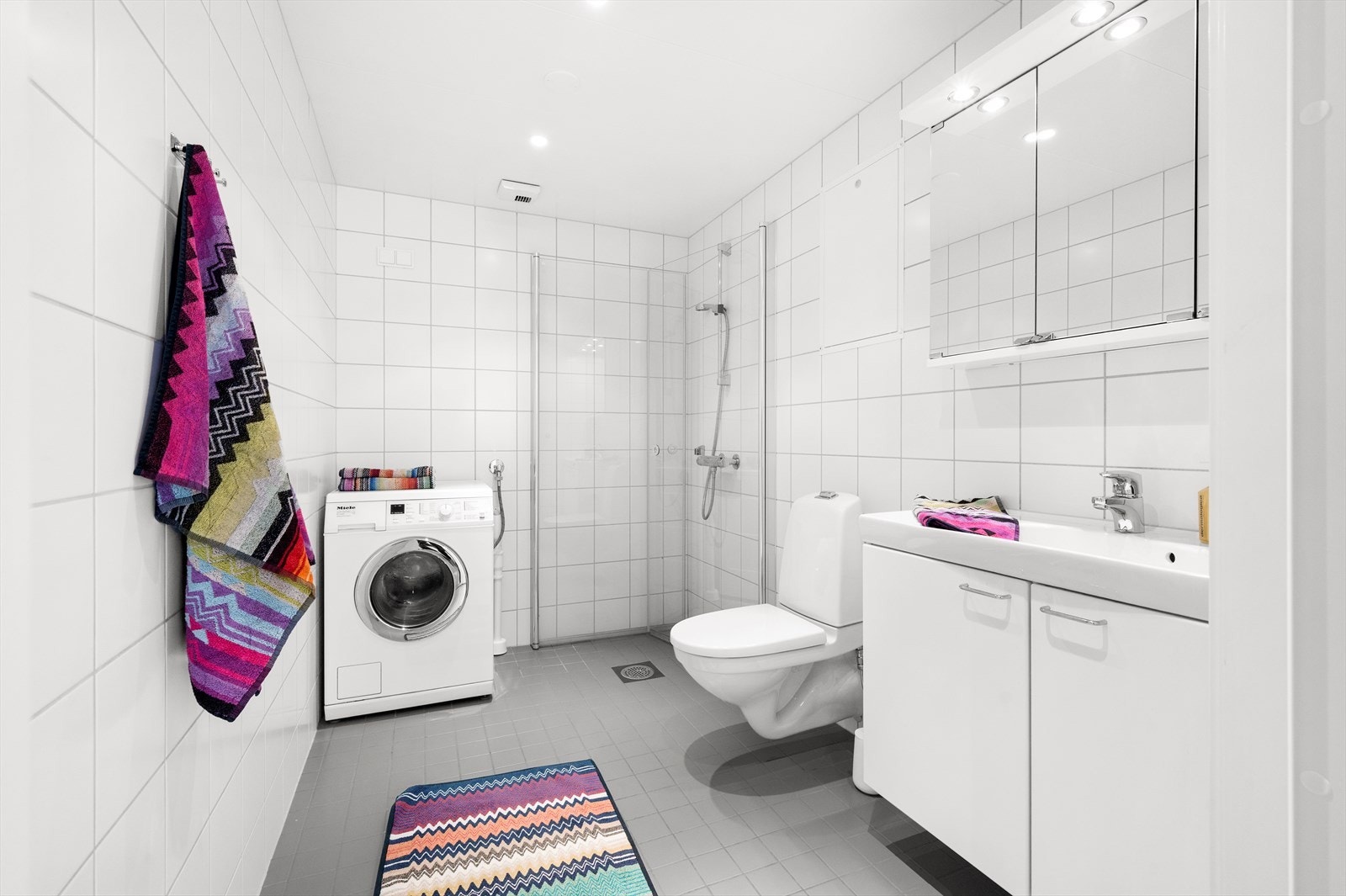 Det andre badet har opplegg for vaskemaskin. Badet har dusjhjørne og veggmontert toalett med utenpåliggende sisterne. Galleribilde