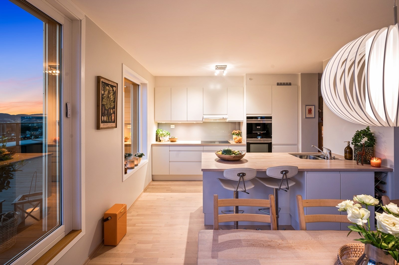 Kjøkkenet er både praktisk og stilfullt, med en moderne innredning med glatte fronter og en romslig barløsning som åpner mot stuen. Galleribilde