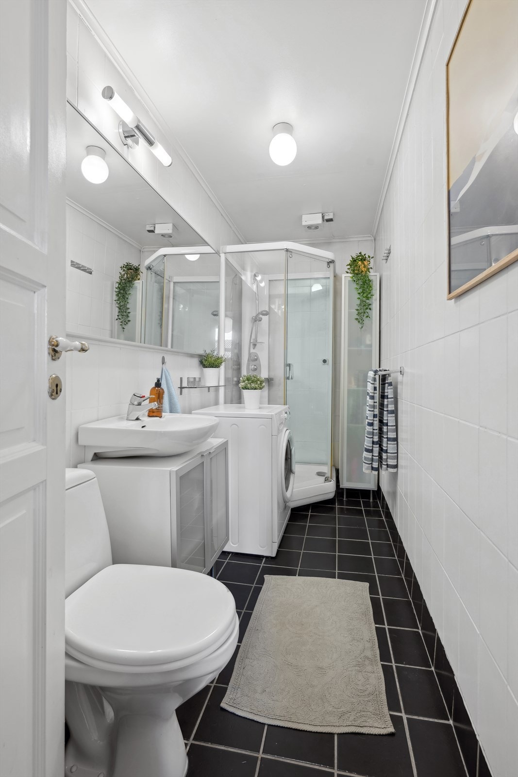 Her er det toalett, servant, dusjkabinett og vaskemaskin. Galleribilde