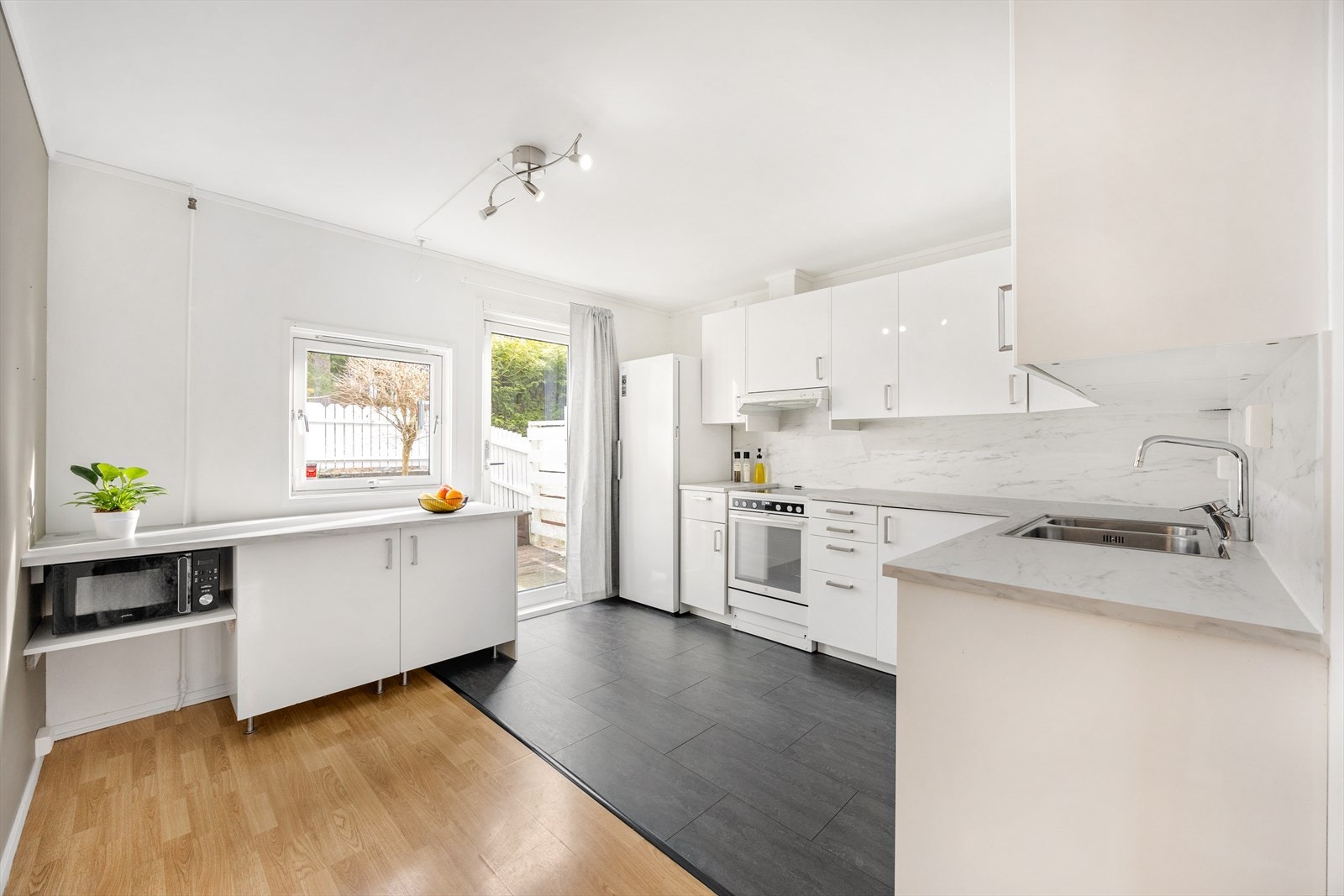 Kjøkkenet er innredet med laminerte skrog og slette fronter i et lyst design. Galleribilde