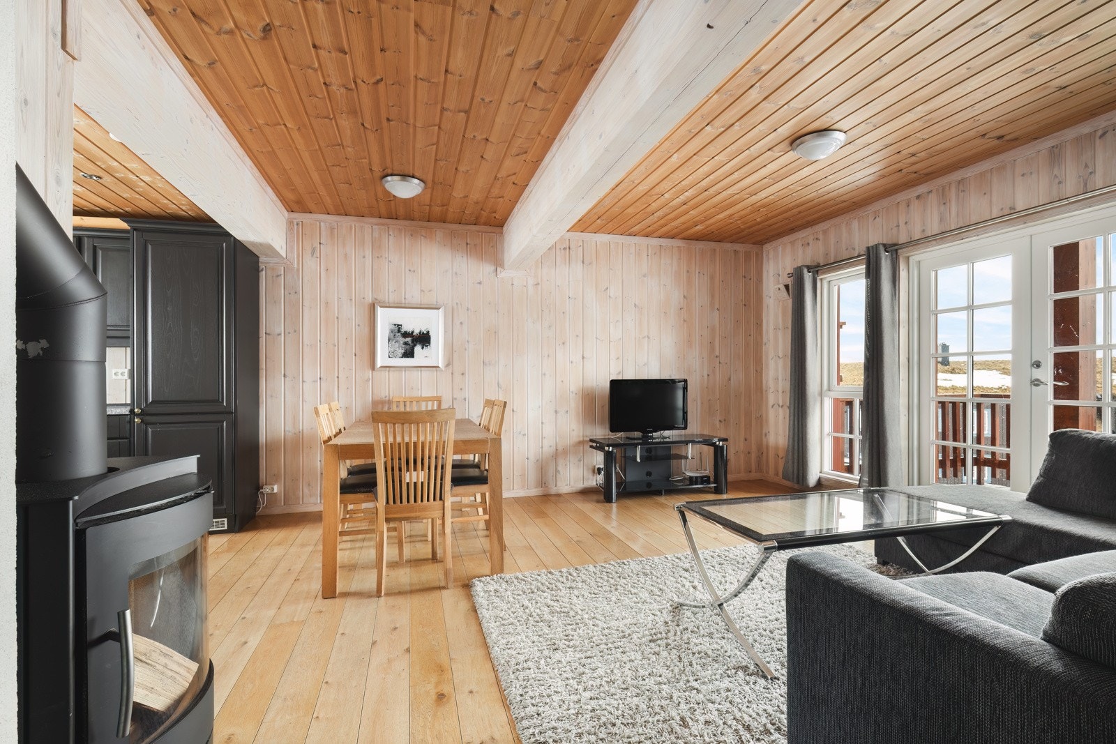 Leiligheten er innredet i typisk hyttestil med trepanel på vegger og i tak. Galleribilde