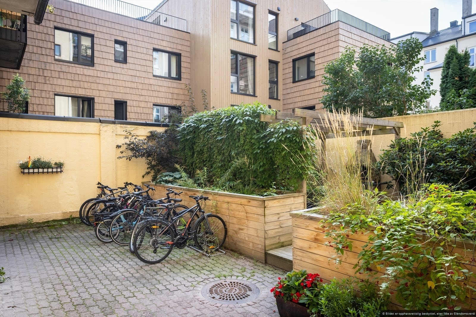 Hyggelig opparbeidet bakgård med sykkelparkering og sittegrupper Galleribilde