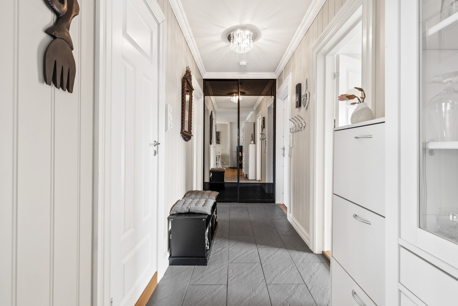 Det er montert skyvedørsgarderobe for praktisk oppbevaring og callinganlegg på vegg Galleribilde