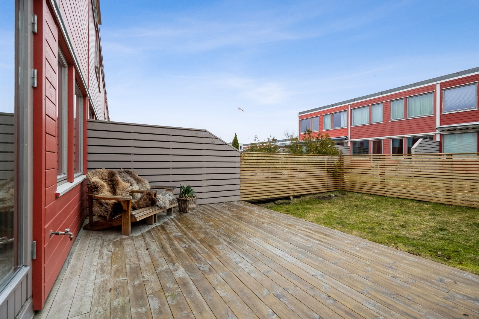 På motsatt side er en terrasse med tilkomst til et inngjerdet hageareal med mye boltreplass. Galleribilde
