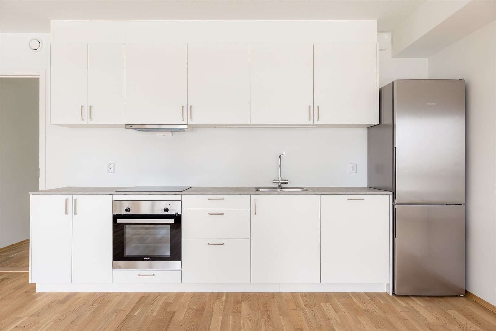 Kjøkken leveres med integrerte hvitevarer som stekeovn, induksjonstopp og oppvaskmaskin. I tillegg frittstående kjøl/fryseskap. Galleribilde