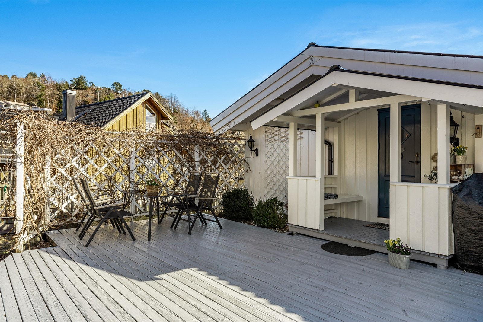 Spiseplassen ved inngangspartiet ligger lunt inntil gjerdet med klatreplanter. Galleribilde