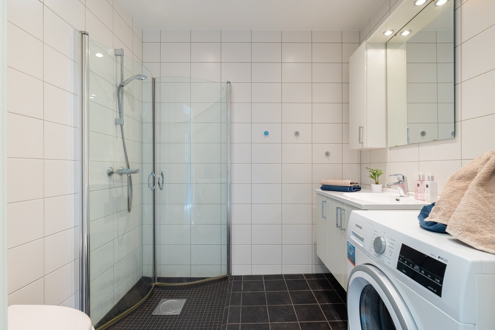 Innredningen består av servant på underskap, speil og veggskap. Videre er det et vegghengt toalett og dusjhjørne med svingbare dører som frigjør plass på gulvet. Galleribilde