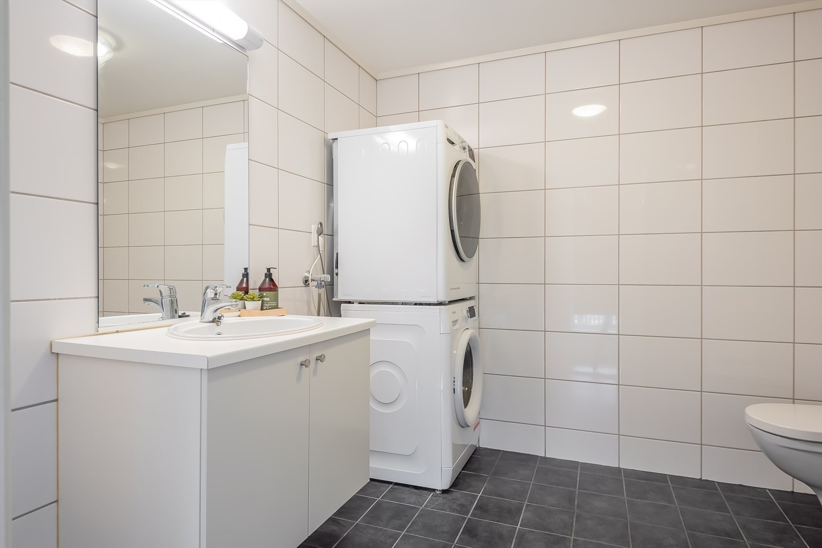 Lyst og flislagt bad på 5,4 m² med behagelig gulvvarme og ferdig opplegg for vaskemaskin. Galleribilde