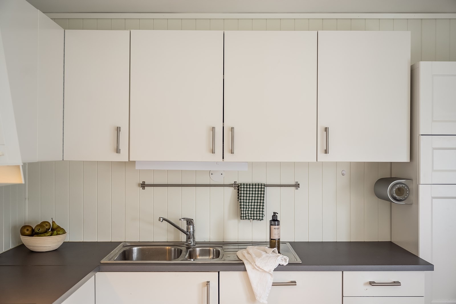 Kjøkkenets utforming gir godt med arbeidsplass på stor benkeplate, og de store vindusflatene gir godt med arbeidslys. Galleribilde