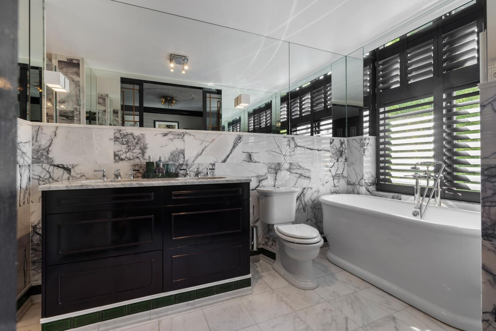 Benkeplate/fliser i marmor og frittstående badekar fra Fired Earth, armatur fra Samuel Heath og messingvask fra Kohler Galleribilde