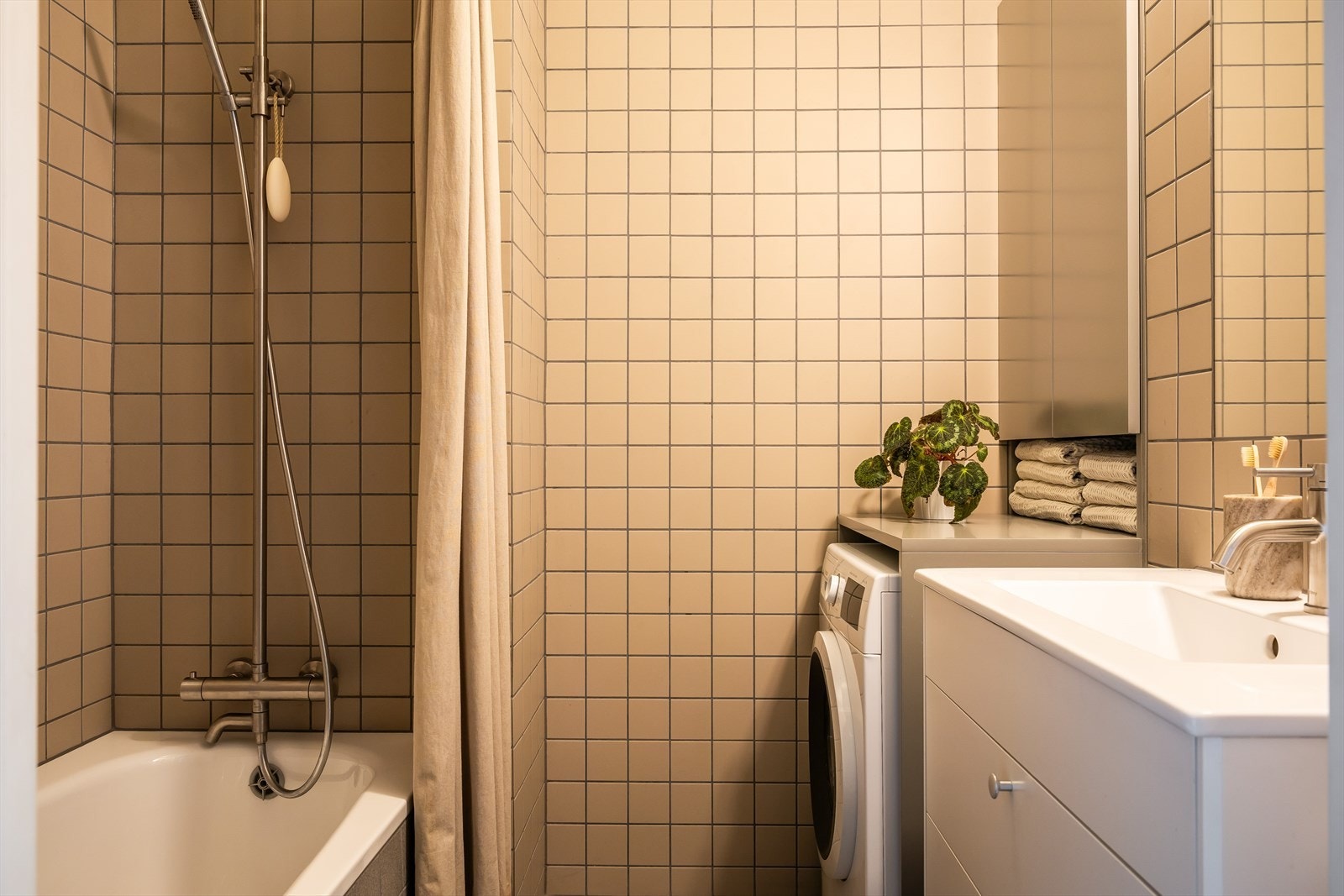 Lekkert bad fra år 2022. Her er det plassbygde skap og opplegg for vaskemaskin Galleribilde