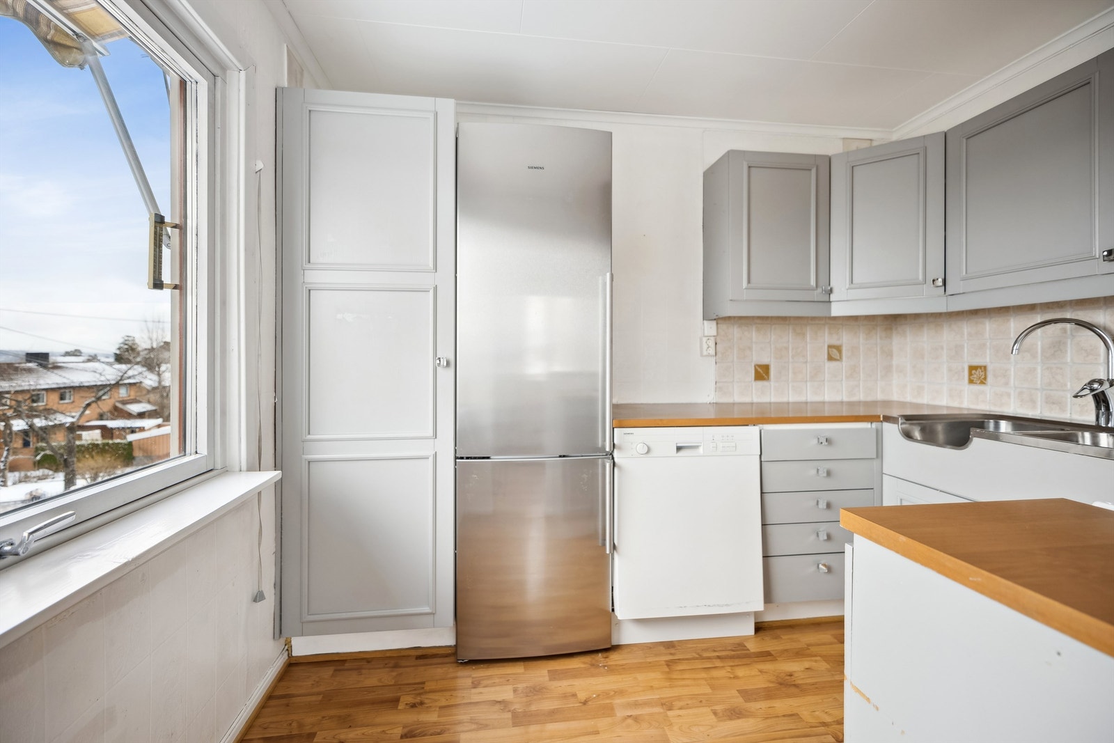 På kjøkkenet er det en lysegrå, profilert kjøkkeninnredning med gode oppbevaringsmuligheter i over- og underskap. Galleribilde