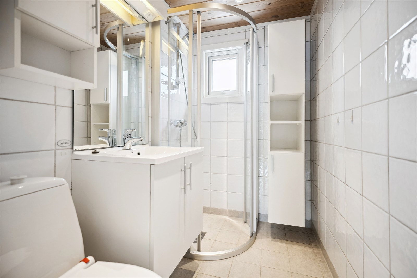 Vis-a-vis soverommet ligger badet med gulvvarme, servant, dusjhjørne og gulvstående toalett. Galleribilde