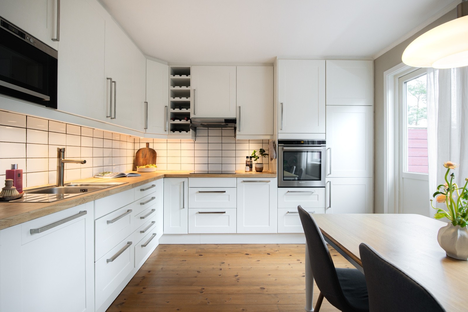 Kjøkkeninnredning med lyse fronter og integrerte hvitevarer. Galleribilde