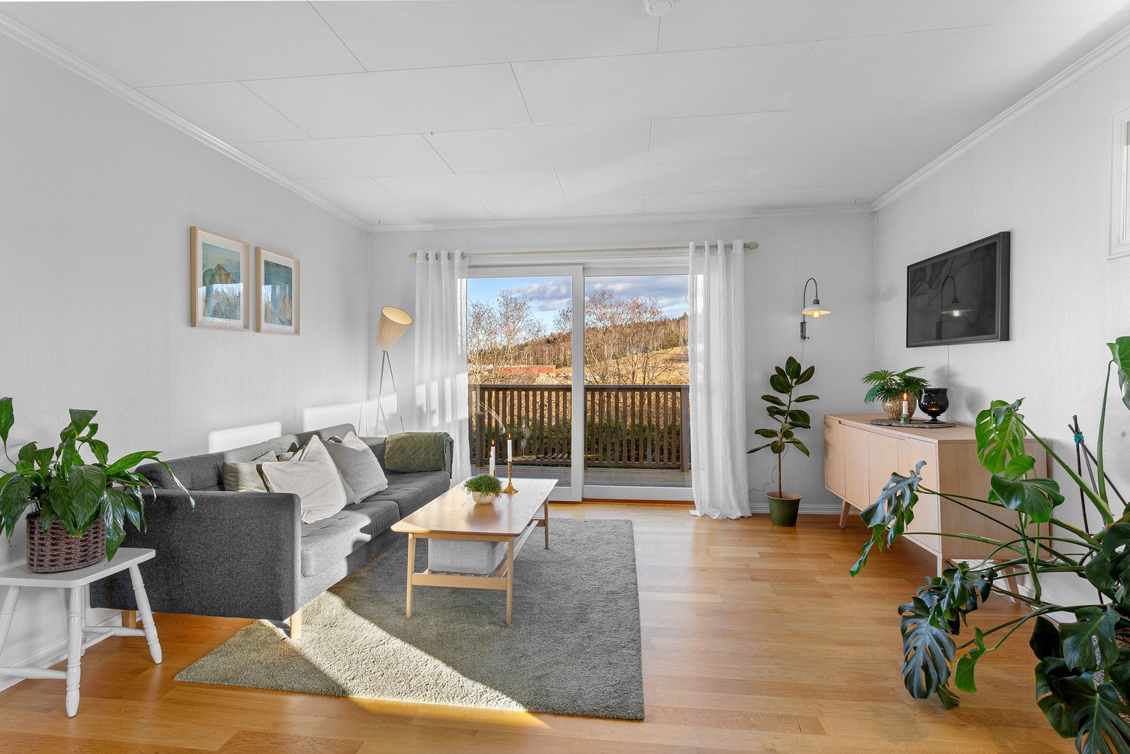 Lys og luftig vinkelstue med sofaområde samt spiseplass Galleribilde