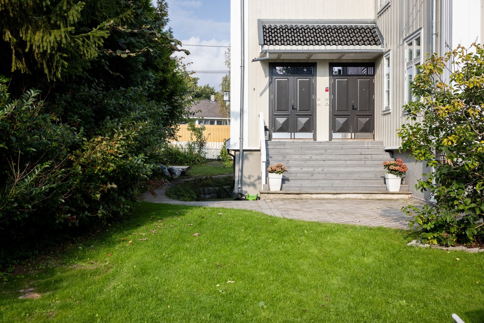 Gårdsplassen og gangarealene er steinsatt, og en pen trapp fører opp til et overbygd inngangsparti. Galleribilde