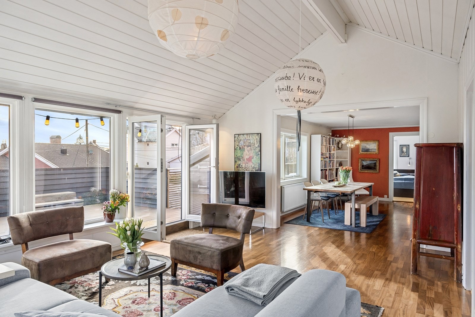 Stuen imponerer med høy takhøyde og hvite panelkledde tak, noe som skaper en åpen og luftig følelse. Galleribilde