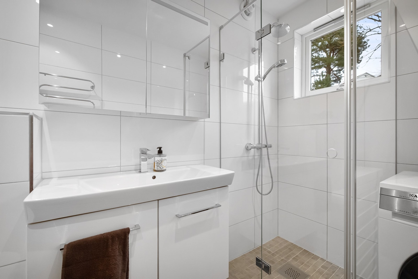 Flott dusjhjørne med innfellbare glassdører og dusjarmatur med både hånd- og regndusj. Opplegg og plass til vaskemaskin og tørketrommel Galleribilde