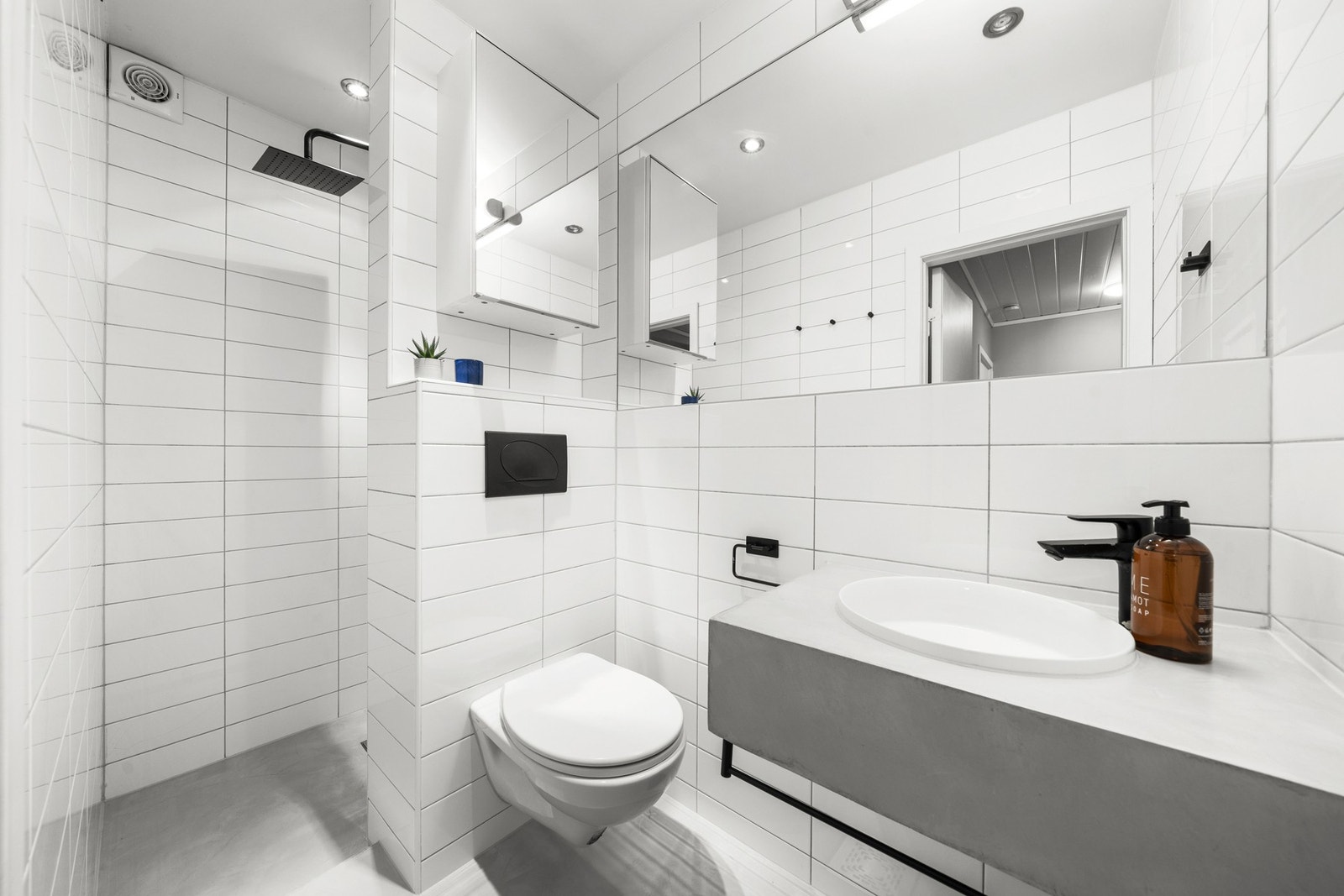 Lekkert bad oppgradert i 2022. Her får du et bad med et moderne uttrykk med hvite fliser og stilige sorte detaljer. Galleribilde