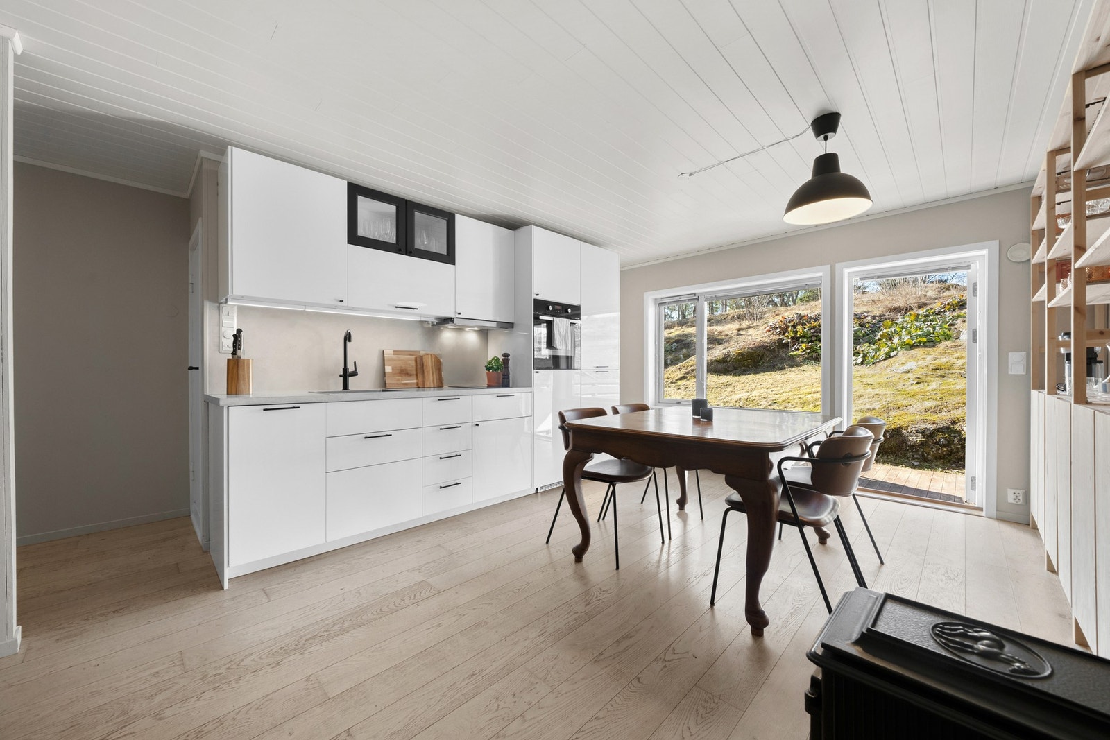 Her har du en tidløs innredning fra 2014 med hvite, glatte fronter og en stilren benkeplate i mikrosement. Galleribilde