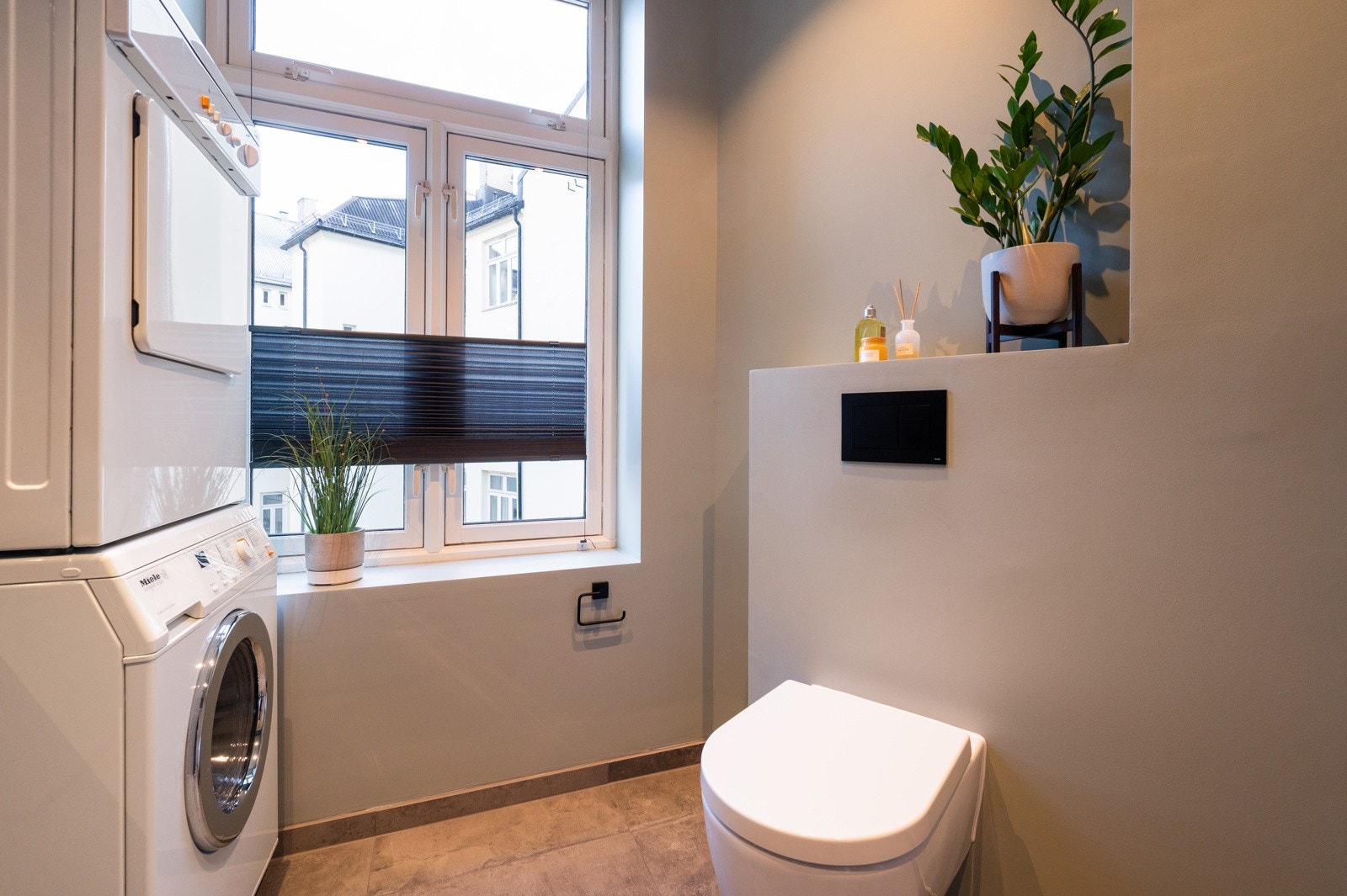 Det vegghengte toalettet med innebygget sisterne gir et moderne og minimalistisk uttrykk. I tillegg er det opplegg for vaskemaskin og tørketrommel. Galleribilde