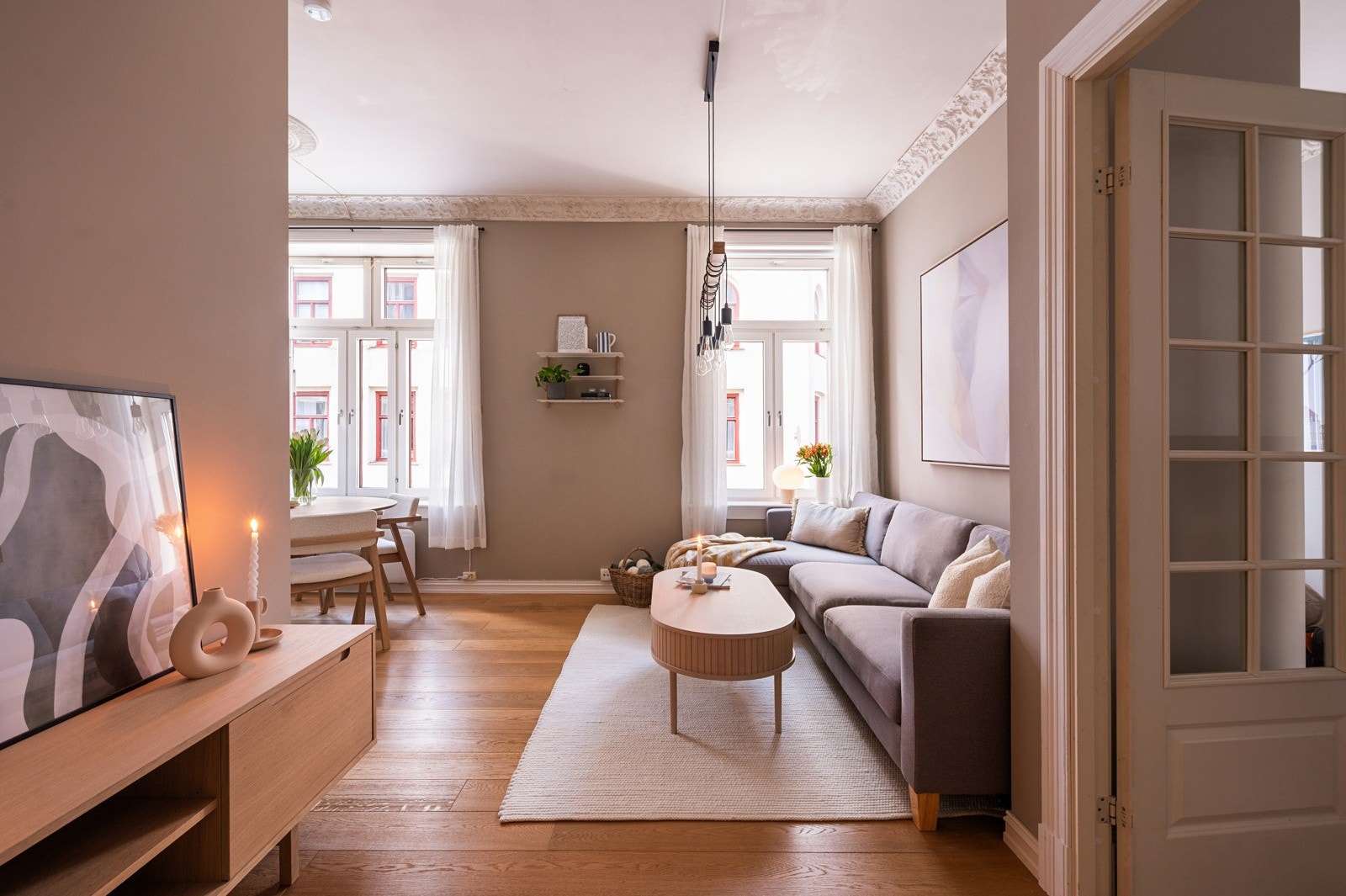 Leiligheten har en lys og innbydende stue med god plass til en romslig sofa og tilhørende møblement Galleribilde