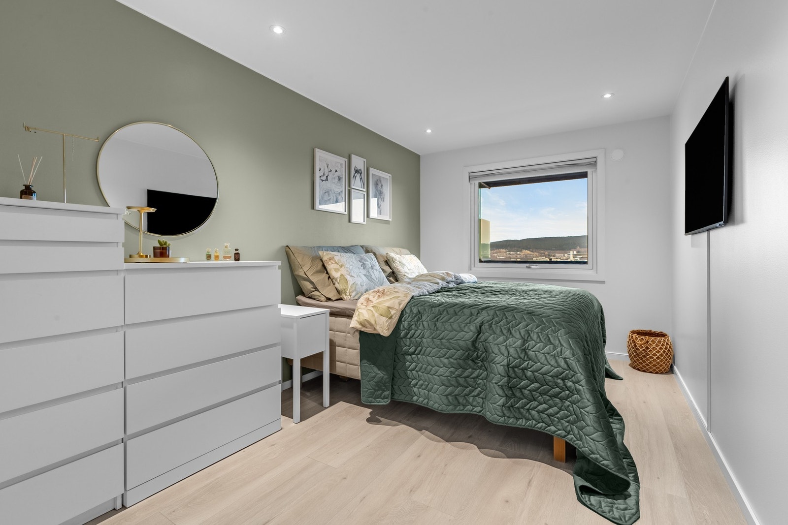 Romslig hovedsoverom med en lun grønn kontrastvegg som skaper en koselig atmosfære. Galleribilde