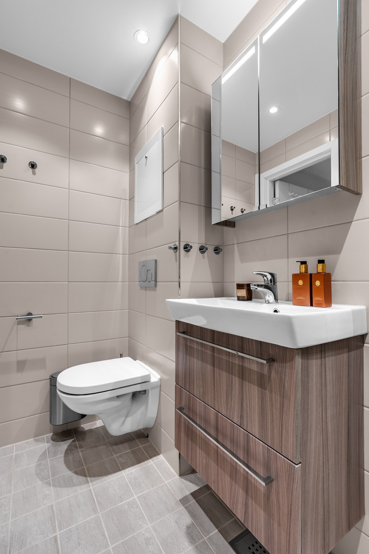 Badeinnredningen består av vegghengt toalett, servant med underskap, overskap med speil og dusjsone. Galleribilde