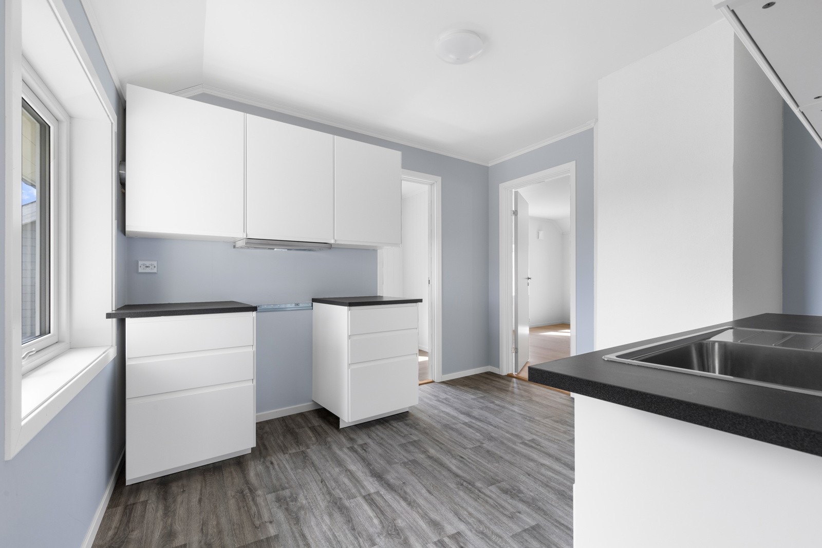 Det er laminerte benkeplater i sort utførelse og en nedfelt oppvaskkum. Ventilatoren er integrert og det er avsatt plass til komfyr, oppvaskmaskin og et kombinert kjøl/frys. Galleribilde