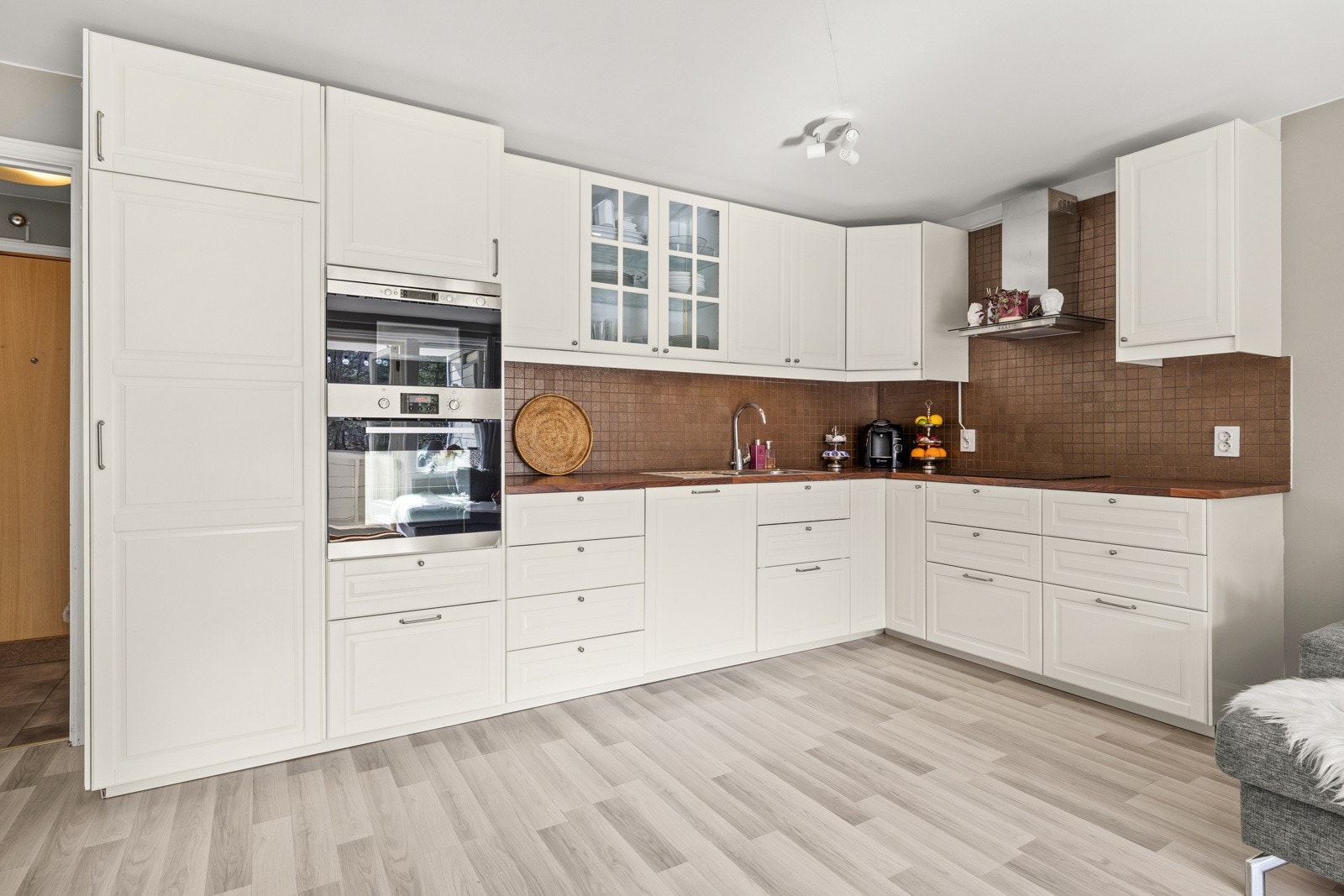 Stilrent kjøkken i åpen løsning med integrerte hvitevarer. Galleribilde