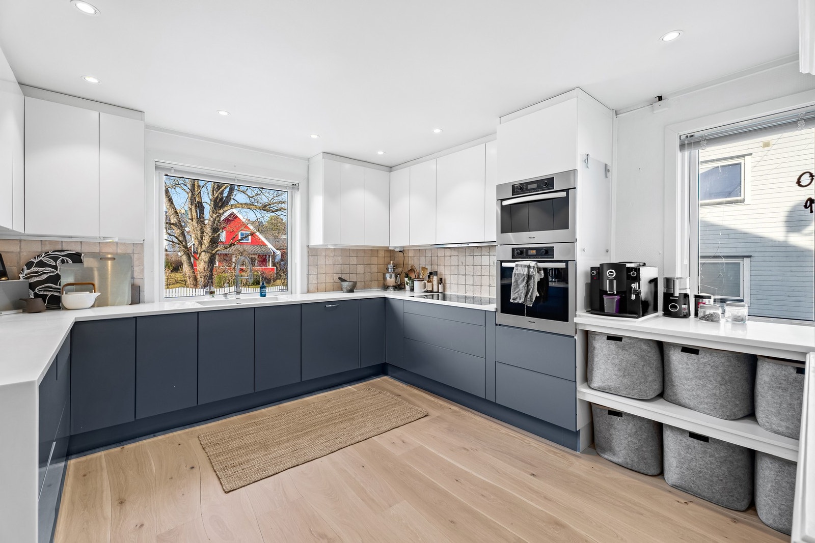 Et svært romslig Norema-kjøkken fra 2014/15 med corian benkeplate, integrert induksjonsplatetopp, stekevon, mikrobølgeovn og oppvaskmaskin Galleribilde