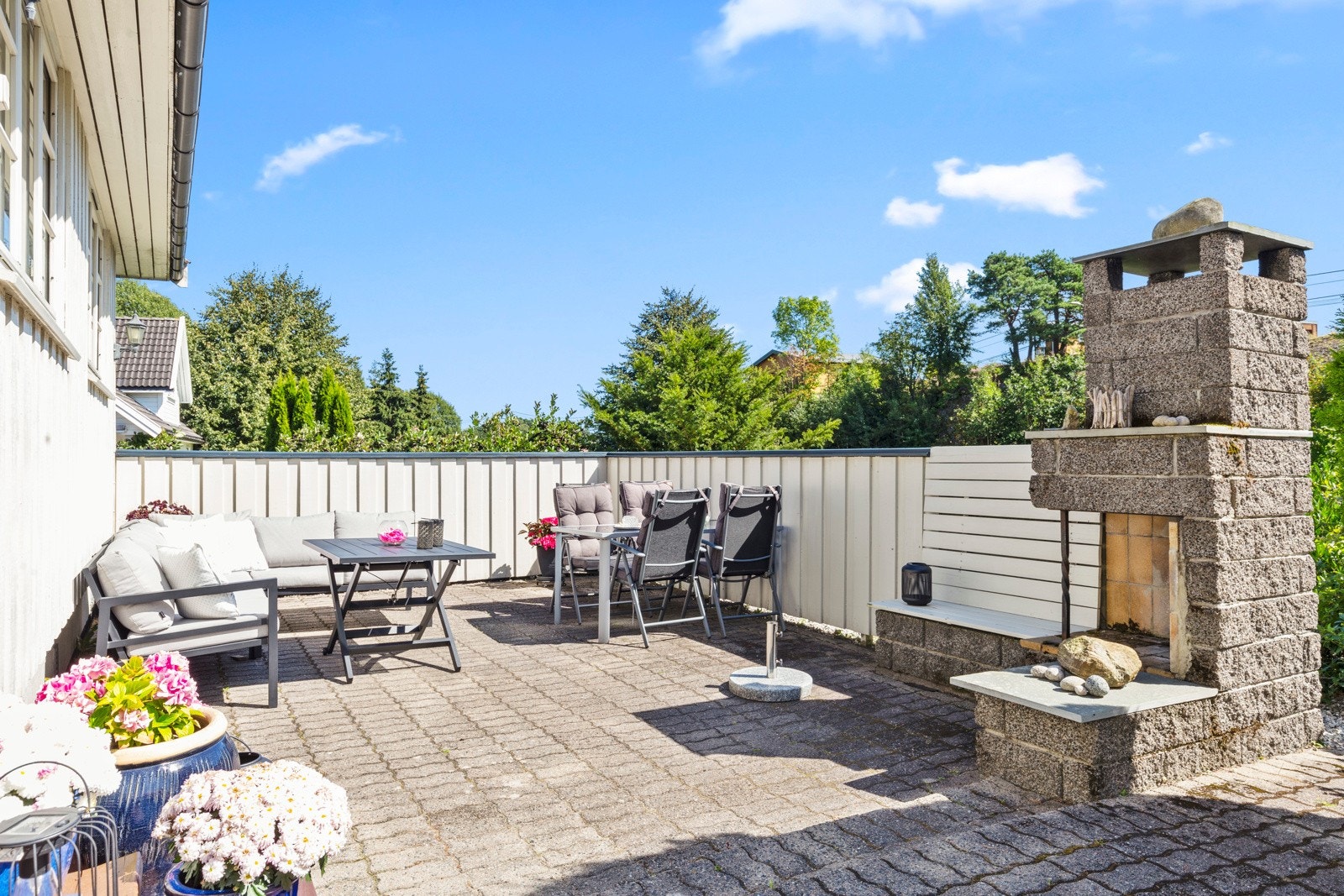 I en lun, egen del er det utepeis og halvhøye levegger Galleribilde