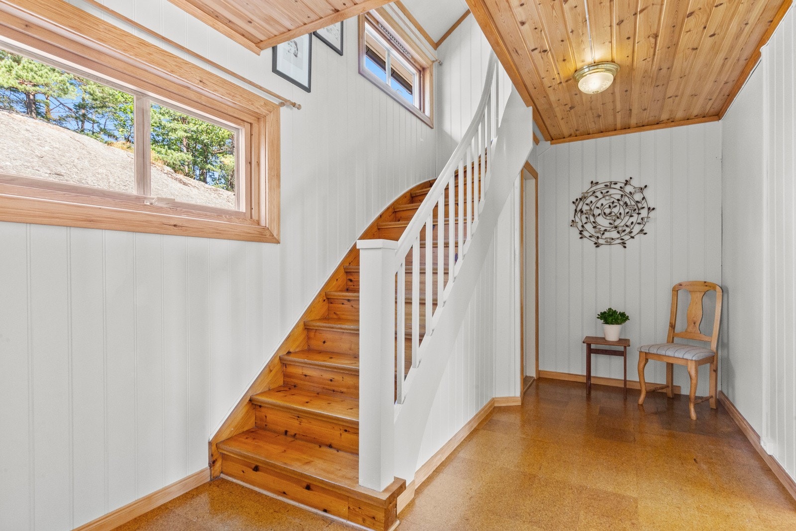 En gyllen trapp i heltre leder opp til soverommene og badet i 2. etasje. Galleribilde