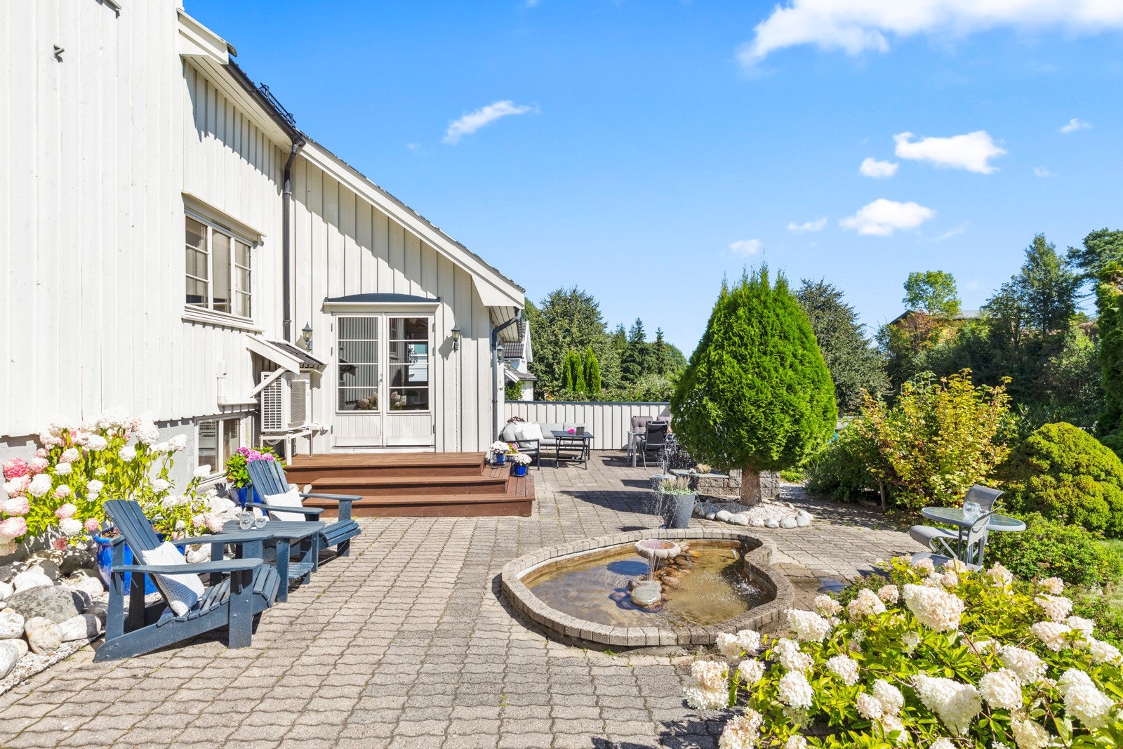 Den steinbelagte uteplassen har adkomst fra den største stuen i første etasje Galleribilde